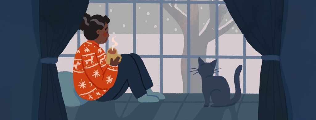 An older black woman sits at a snowy window wearing a bright red christmas sweater.