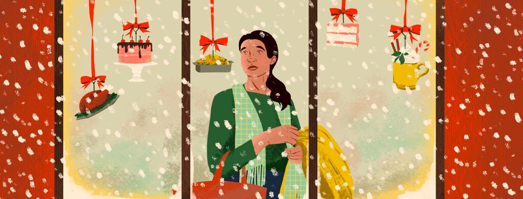 A woman is viewed through a store window. She is holding a bag and jacket and looking sadly at blown glass ornaments hanging in the window depicting different kinds of decadent foods. It is snowing outside the window.